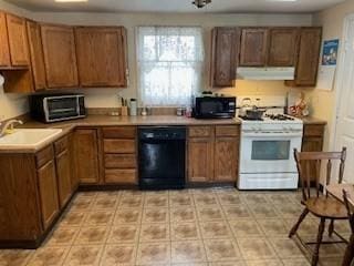 kitchen with black appliances, under cabinet range hood, a sink, and brown cabinets