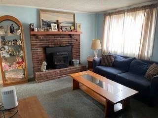 living area with carpet floors and a brick fireplace