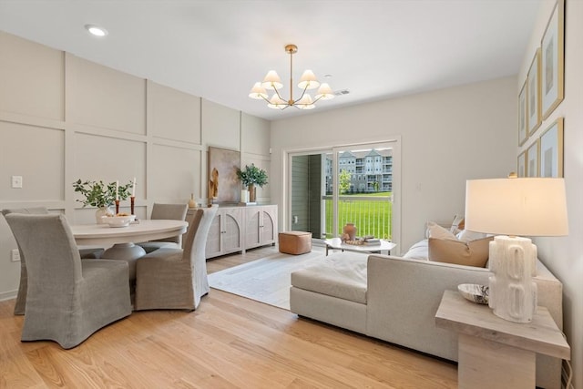 dining area featuring light hardwood / wood-style flooring and a notable chandelier