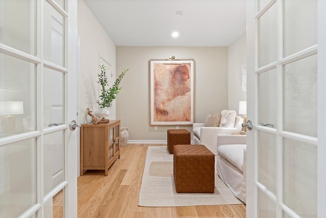 sitting room featuring french doors and light hardwood / wood-style floors