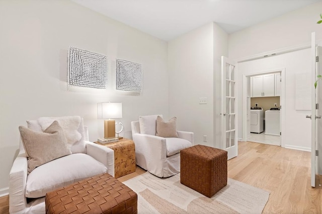 living area featuring separate washer and dryer, french doors, and light hardwood / wood-style flooring