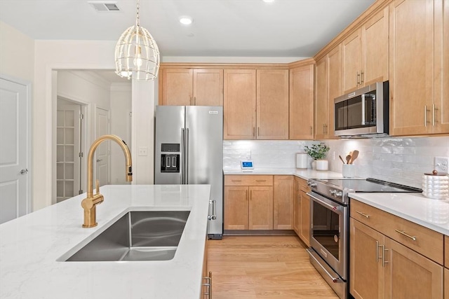 kitchen featuring sink, light hardwood / wood-style flooring, backsplash, a chandelier, and appliances with stainless steel finishes