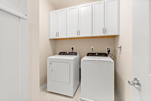 washroom featuring washer and dryer and cabinets