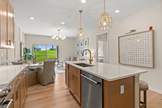 kitchen featuring a kitchen island with sink, sink, a chandelier, and light wood-type flooring