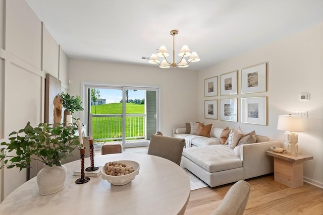 dining area with an inviting chandelier and light hardwood / wood-style flooring