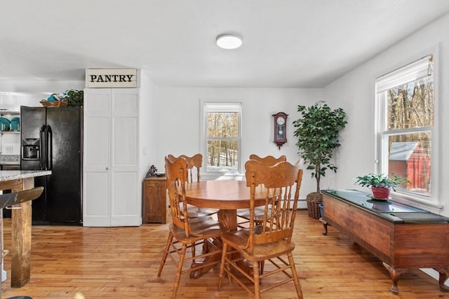 dining area with baseboard heating and light hardwood / wood-style floors