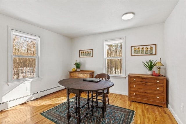 dining room featuring light wood-type flooring, a wealth of natural light, and baseboard heating