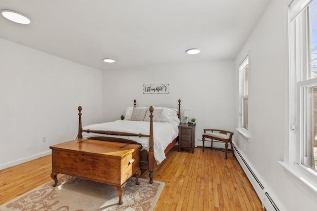 bedroom with baseboard heating and light wood-type flooring