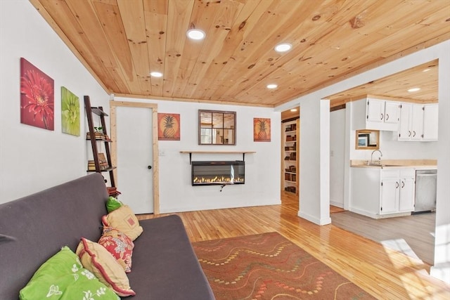 unfurnished living room with sink, wooden ceiling, and light wood-type flooring