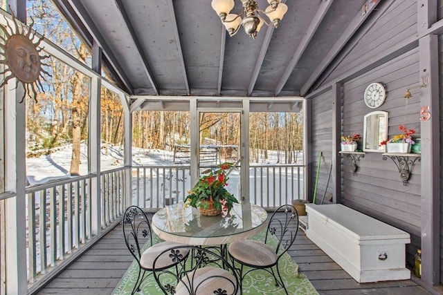 sunroom / solarium featuring vaulted ceiling with beams and an inviting chandelier