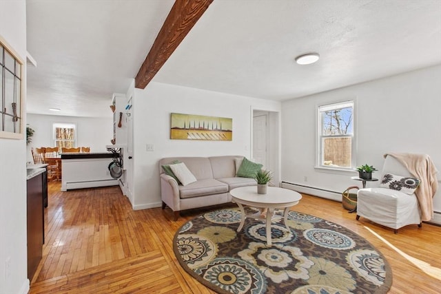 living room with a wealth of natural light, a baseboard radiator, and hardwood / wood-style flooring