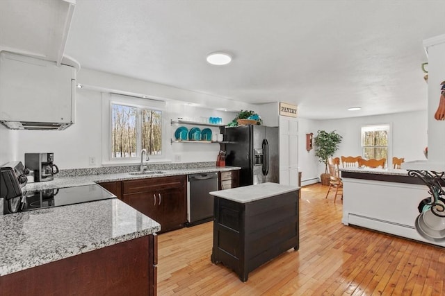 kitchen with sink, dishwasher, range, a center island, and black refrigerator with ice dispenser