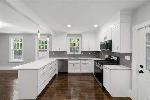 68 Putnam St, Weymouth, MA 02189 - kitchen with appliances with stainless steel finishes, a peninsula, healthy amount of natural light, dark wood finished floors, and recessed lighting