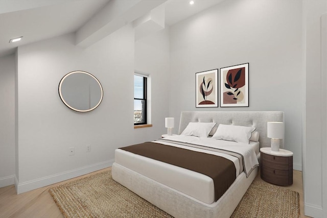 bedroom featuring baseboards, wood finished floors, and vaulted ceiling