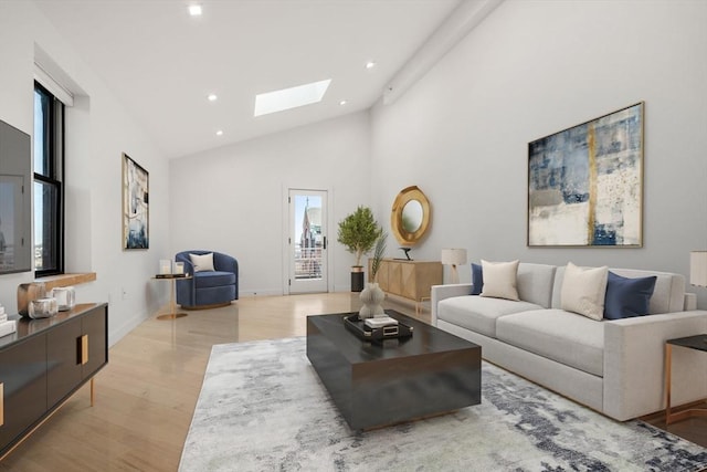 living room with baseboards, light wood finished floors, high vaulted ceiling, a skylight, and recessed lighting