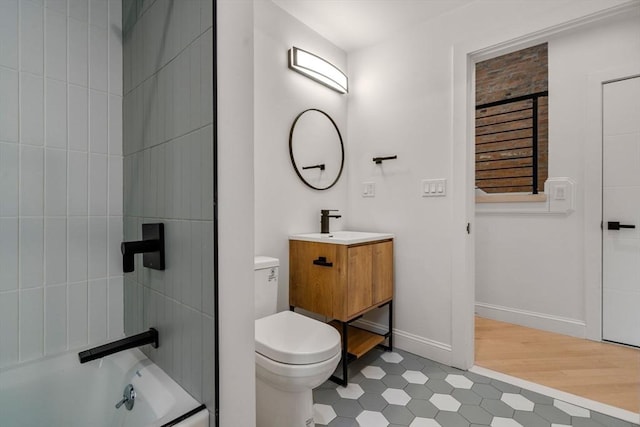 full bath featuring tub / shower combination, toilet, vanity, and baseboards