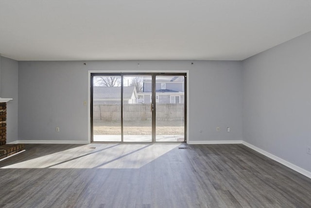 unfurnished living room with baseboards and wood finished floors