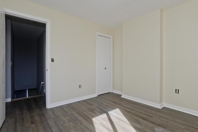 unfurnished room with baseboards and wood finished floors