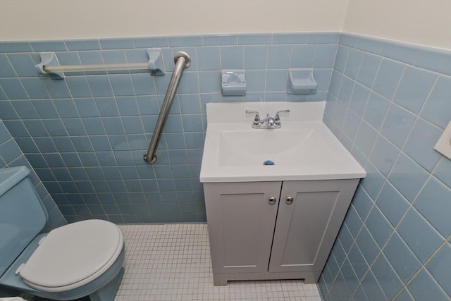 bathroom featuring vanity, tile patterned floors, toilet, and tile walls