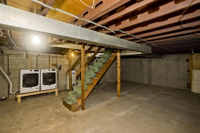 unfinished basement featuring stairway and independent washer and dryer