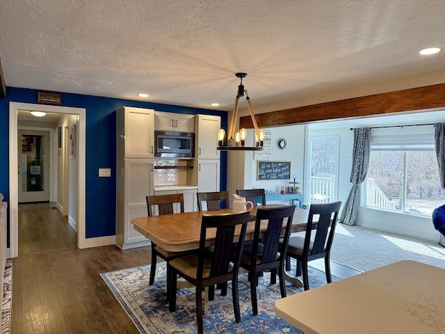 dining area with dark wood-type flooring, recessed lighting, baseboards, and a textured ceiling