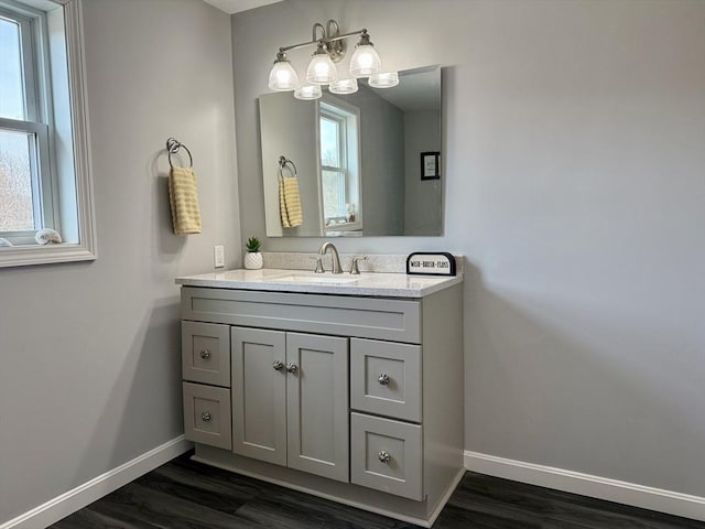 bathroom featuring baseboards, wood finished floors, and vanity