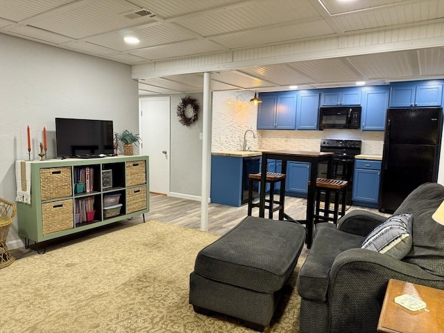 living area featuring light wood-type flooring, baseboards, and visible vents