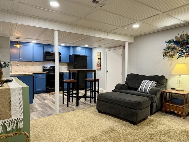 living area featuring light wood-style flooring, recessed lighting, and visible vents