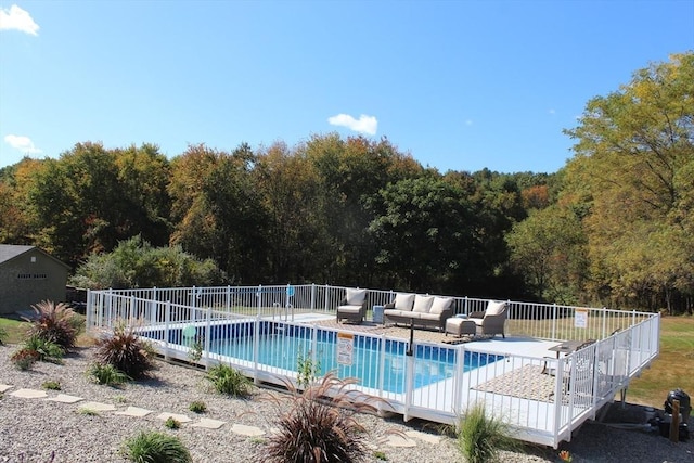 community pool with a patio area, an outdoor living space, and fence