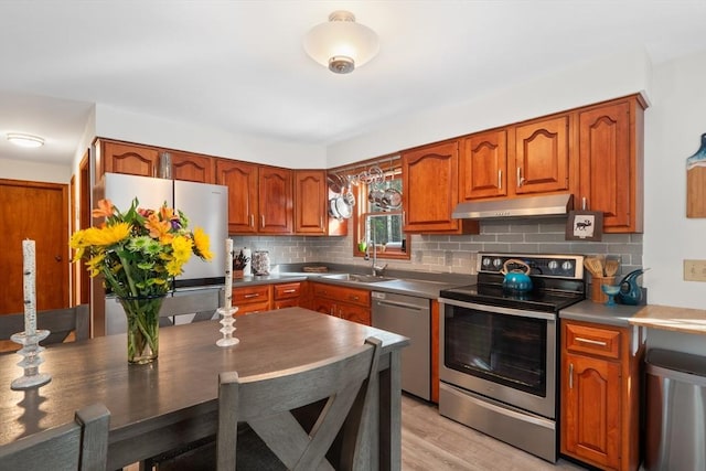 kitchen featuring sink, backsplash, light hardwood / wood-style flooring, and appliances with stainless steel finishes