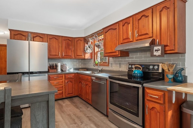 kitchen featuring sink, light hardwood / wood-style floors, appliances with stainless steel finishes, and decorative backsplash