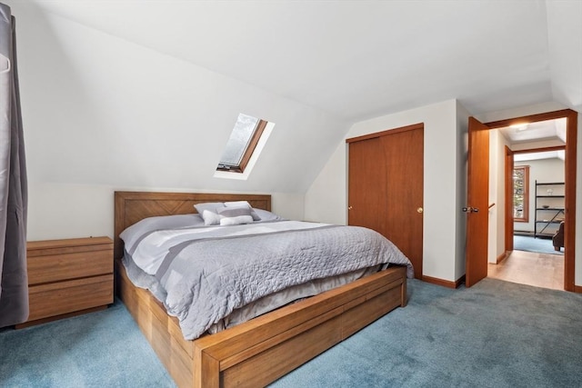 bedroom with vaulted ceiling with skylight, carpet flooring, and a closet