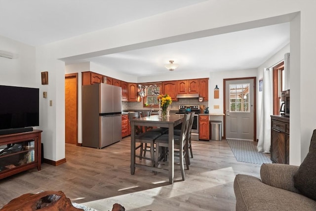 kitchen featuring light hardwood / wood-style floors, appliances with stainless steel finishes, tasteful backsplash, and sink