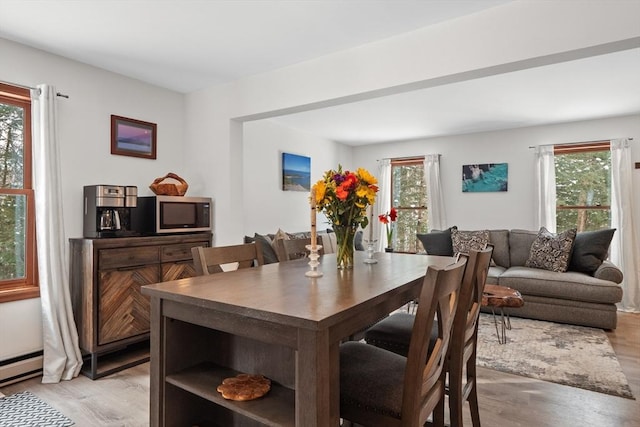 dining space with light hardwood / wood-style floors and plenty of natural light