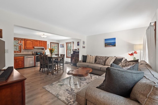 living room featuring sink, a baseboard radiator, and light hardwood / wood-style floors