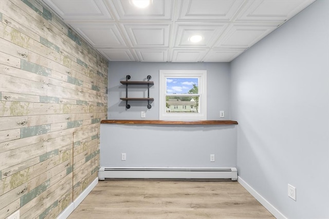 26 W Park St, Franklin, MA 02038 - unfurnished room featuring wooden walls, baseboard heating, light wood-type flooring, an ornate ceiling, and an accent wall