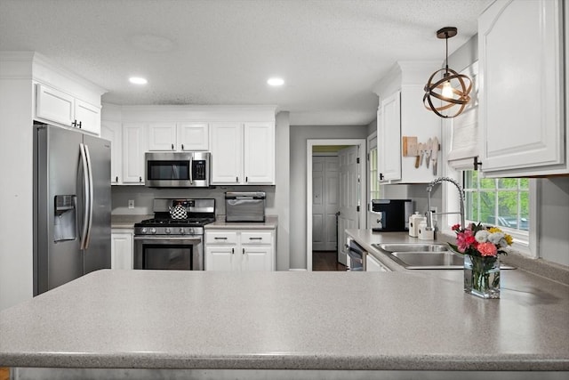 2240 Turnpike St, North Andover, MA 01845 - kitchen with appliances with stainless steel finishes, a sink, a peninsula, white cabinetry, and recessed lighting
