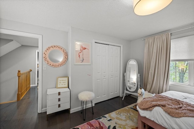 2240 Turnpike St, North Andover, MA 01845 - bedroom featuring a closet, dark wood-type flooring, a textured ceiling, and baseboards
