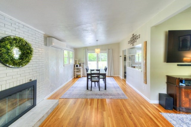36 Winthrop St, West Boylston, MA 01583 - dining room with a wall mounted AC, light wood-style flooring, baseboards, and a fireplace