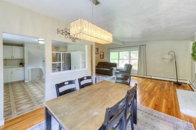 36 Winthrop St, West Boylston, MA 01583 - dining room featuring light wood-style floors, a chandelier, and a baseboard heating unit