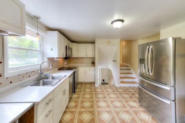 36 Winthrop St, West Boylston, MA 01583 - kitchen featuring stainless steel appliances, a sink, light countertops, backsplash, and decorative light fixtures