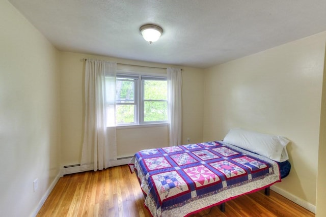 36 Winthrop St, West Boylston, MA 01583 - bedroom with wood finished floors, baseboards, and a baseboard heating unit