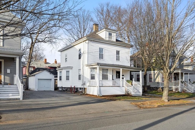 view of front of property featuring a porch, a garage, and an outbuilding