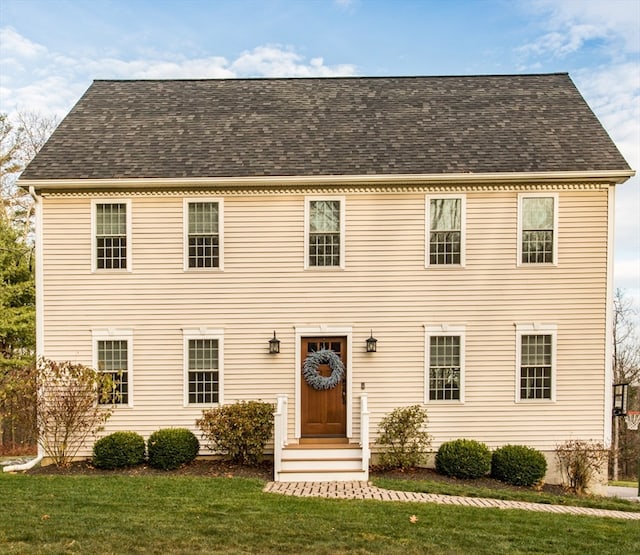 colonial inspired home featuring a front lawn