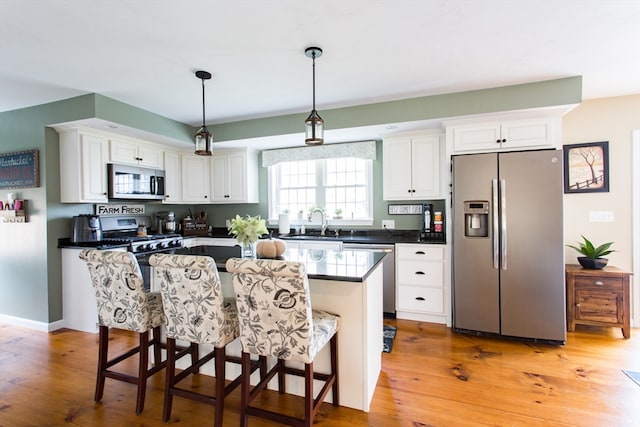 kitchen with white cabinetry, stainless steel appliances, and light hardwood / wood-style floors