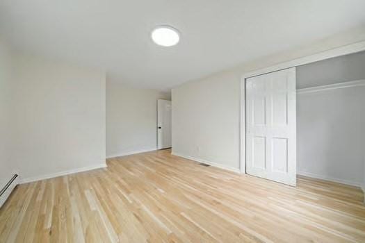 368 King St, Hanover, MA 02339 - unfurnished bedroom with light wood finished floors, a closet, baseboards, and baseboard heating