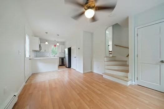 368 King St, Hanover, MA 02339 - unfurnished living room with baseboard heating, a ceiling fan, light wood-style floors, stairs, and arched walkways