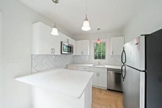 368 King St, Hanover, MA 02339 - kitchen with stainless steel appliances, a sink, white cabinetry, and light countertops