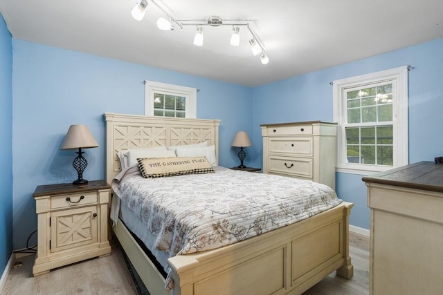 bedroom with light wood finished floors and baseboards
