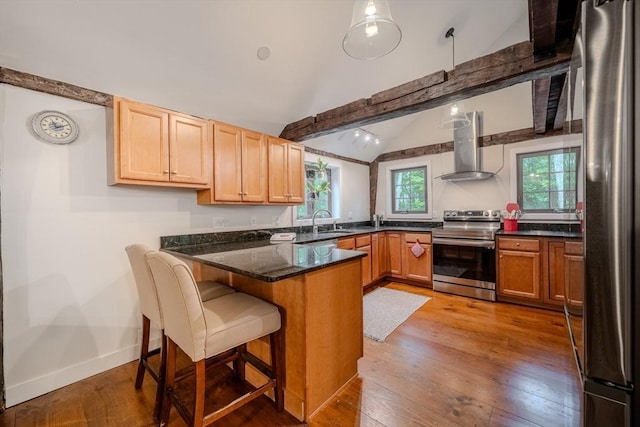 43 Mill Rd, North Andover, MA 01845 - kitchen featuring stainless steel appliances, wall chimney exhaust hood, a peninsula, hardwood / wood-style floors, and a kitchen bar